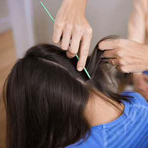 person combing through child's hair looking for signs of head lice